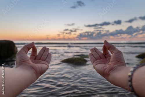 meditasyon hand sign, Healthy Lifestyle and Yoga Concept. Close-up hands. Woman do yoga outdoors at sunrise in lotus position. Woman exercising and meditating in morning. Namaste. photo