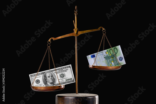 US Dollar bill and Euro bancnote signs on antique mechanical weighing scale as symbol of money exchange rate. Economic and monetary system concept. photo