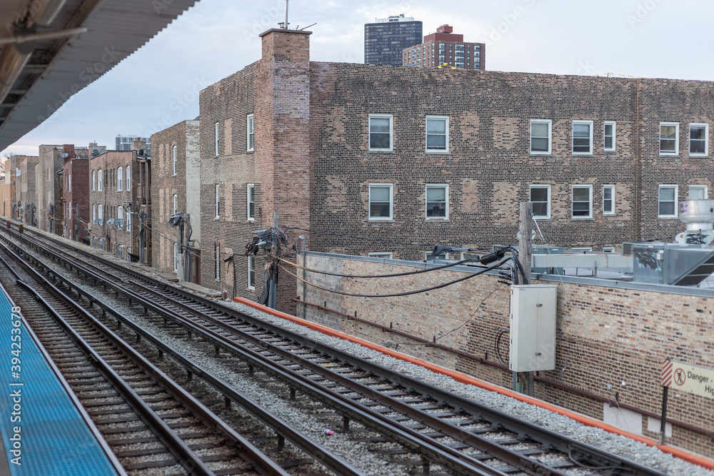Elevated subway tracks running alongside vintage brick buildings in urban Chicago