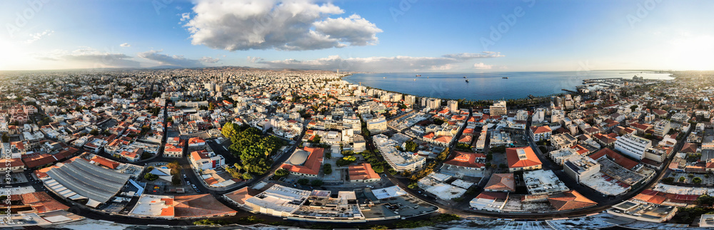 Fototapeta premium View of the city of Larnaca from above, shooting from a quadrocopter. Flat frame on the city streets. Horizontal panorama of southern Cyprus with the horizon line. The coastline and the sea.