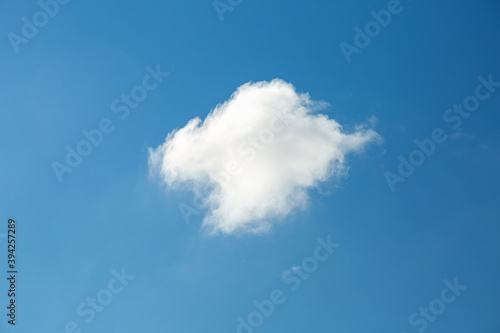 Single white cloud on blue sky background in daytime.