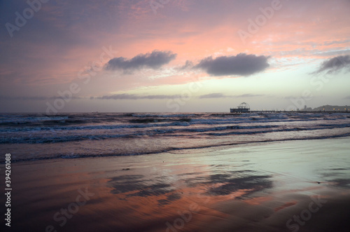 Sunset at the sea. Sandy beach and sea waves during golden sunset. Landscape. 