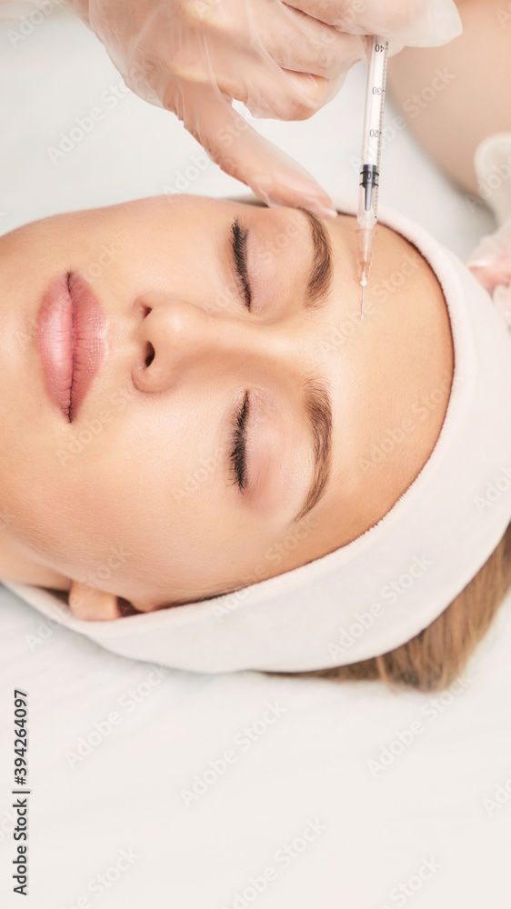 Forehead injection at spa salon. Doctor hands. Closeup. High quality. Pretty female patient. Beauty treatment. Healthy skin procedure. Young woman face. Light background. Plasmolifting rejuvenation Forehead injection at spa salon. Doctor hands. Closeup. High quality. Pretty female patient. Beauty treatment. Healthy skin procedure. Young woman face. Light background. Plasmolifting rejuvenation