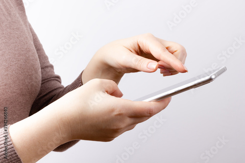 Smartphone in the hands of a young girl. Finger pointing at the screen of a mobile phone. Communication concept.