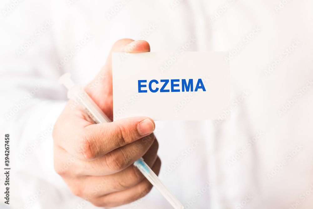 Word eczema on a white background with a syringe in hand. Medicine concept Word eczema on a white background with a syringe in hand. Medicine concept