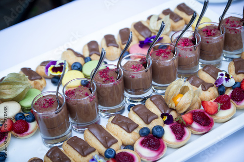 Selection of colourful small sweet desserts at a banquette buffet table. Sweet snacks tray at summer party. photo