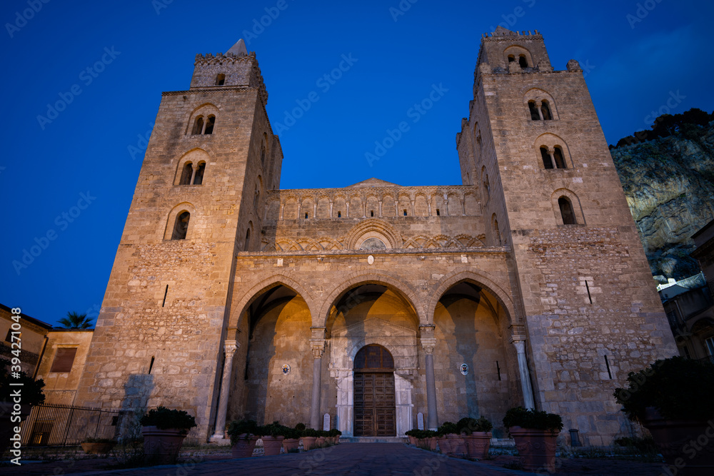 Night photograph of the cathedral in Cefalu, Italy, with the mountains in the background.
