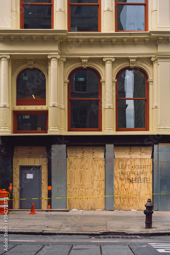 NYC retailer small business boarding up their storefronts with plywood over Broadway building in fear of looting damage during the BLM protests.