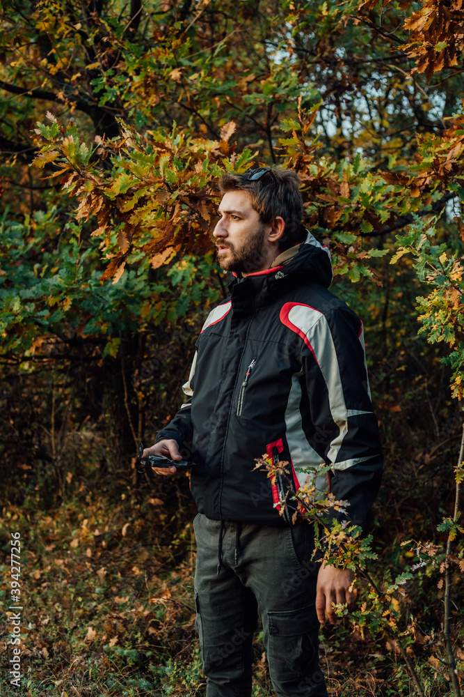 A young man uses a military compass for orientation in nature, talking on the phone, surrounded by fog. A young man uses a military compass for orientation in nature, talking on the phone, surrounded by fog.