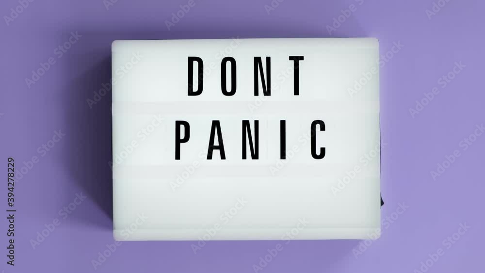 Lightbox with a words text Don't Panic board on violet background. Concept panic mood during quarantine period, pandemic of coronavirus. Lightbox with a words text Don't Panic board on violet background. Concept panic mood during quarantine period, pandemic of coronavirus.