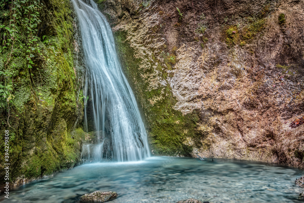 Landscape view of a colorful waterfall and small basin at bottom. Cerinski vir, Samoborsko gorje, Croatia.