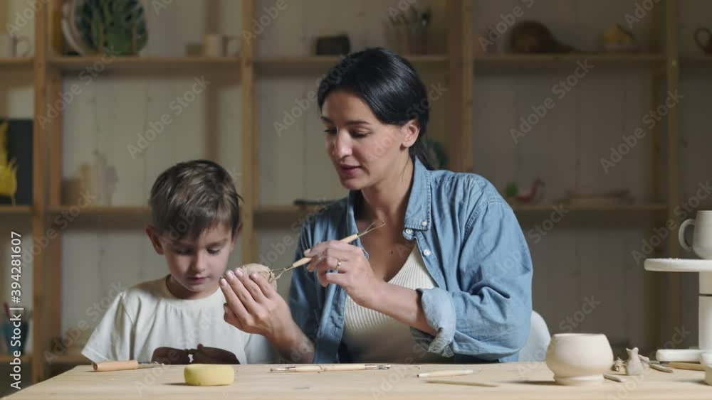 Little boy and female teacher plays with clay in pottery class Little boy and female teacher plays with clay in pottery class