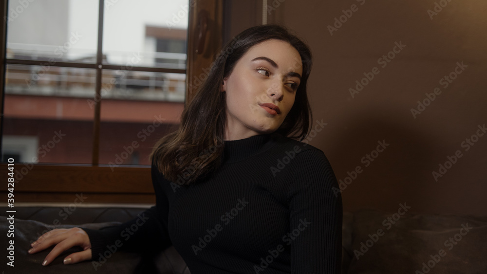Beautiful dressed girl sitting on sofa close-up, sad and relaxing, home health and comfort concept Beautiful dressed girl sitting on sofa close-up, sad and relaxing, home health and comfort concept