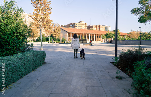 Pretty young woman walks her dog with one eye of each color. Love between owner and dog