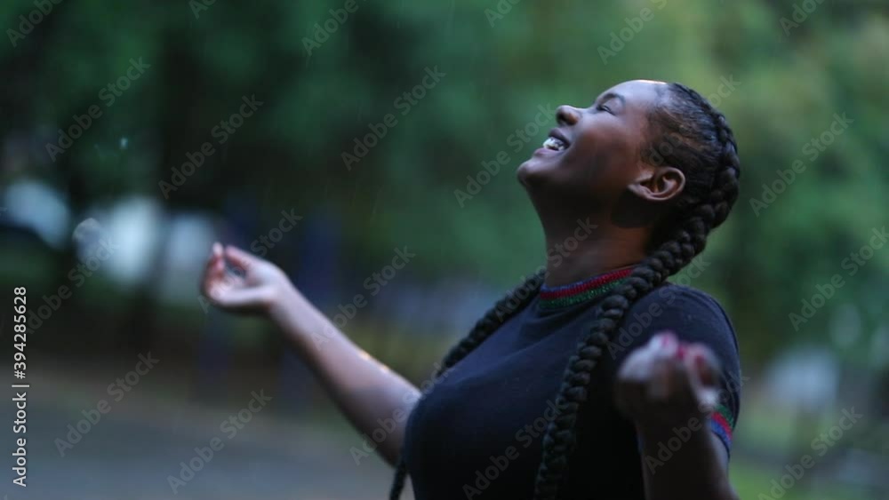 Happy African girl standing outdoors in the rain Happy African girl standing outdoors in the rain
