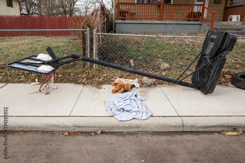 Fotografija Trash lays on the ground in front of chain link fence in urban area