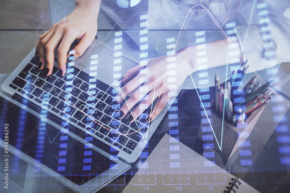 Double exposure of woman hands typing on computer and forex chart hologram drawing. Stock market invest concept.