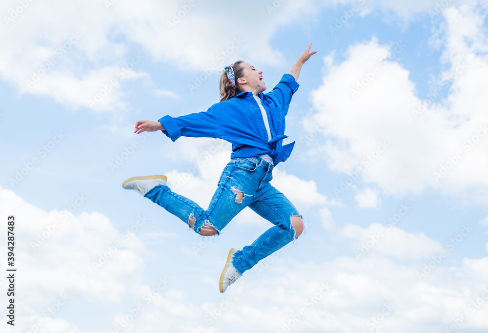 teen girl wearing casual fashion clothes jumping high on sky background, energy