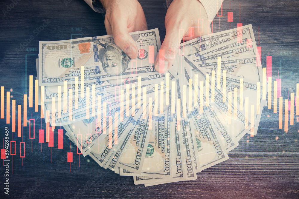 Multi exposure of financial graph drawing hologram and USA dollars bills and man hands. Analysis concept. Multi exposure of financial graph drawing hologram and USA dollars bills and man hands. Analysis concept.