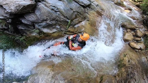 Man going down a slide in the Peira canyon, a spectacular canyon located in the French Alps. photo