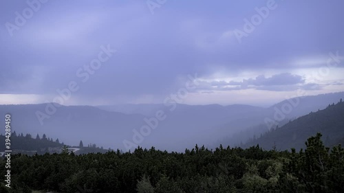 Dramatic and rainheavy weather rushing over forested landscape in Italy as the weather change from overcast to rain to sunny photo