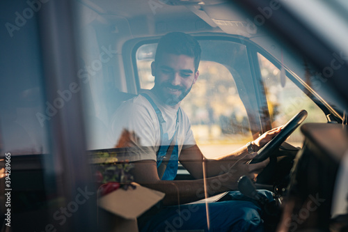 Young and handsome Hispanic male working in daily home delivery service. He is positive and smiled.