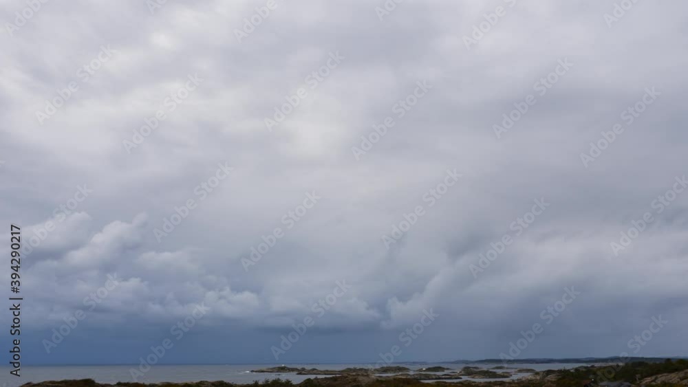 Dark Blue Grey Clouds Roll in Over Tranquil Coastal Landscape, Stormy Cloudscape Dark Blue Grey Clouds Roll in Over Tranquil Coastal Landscape, Stormy Cloudscape