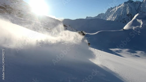 Freeride Skiing with lots of fresh deep snow in Tirol. Backcountry skiing with a ski guide in perfect snow conditions. Professional Male Skier with perfect ski turns offpist. Freeride fun slomo. photo