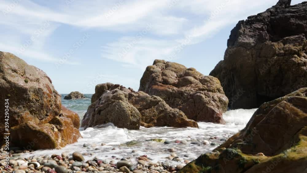 View of the waves crashing into the rocks during a sunny day View of the waves crashing into the rocks during a sunny day