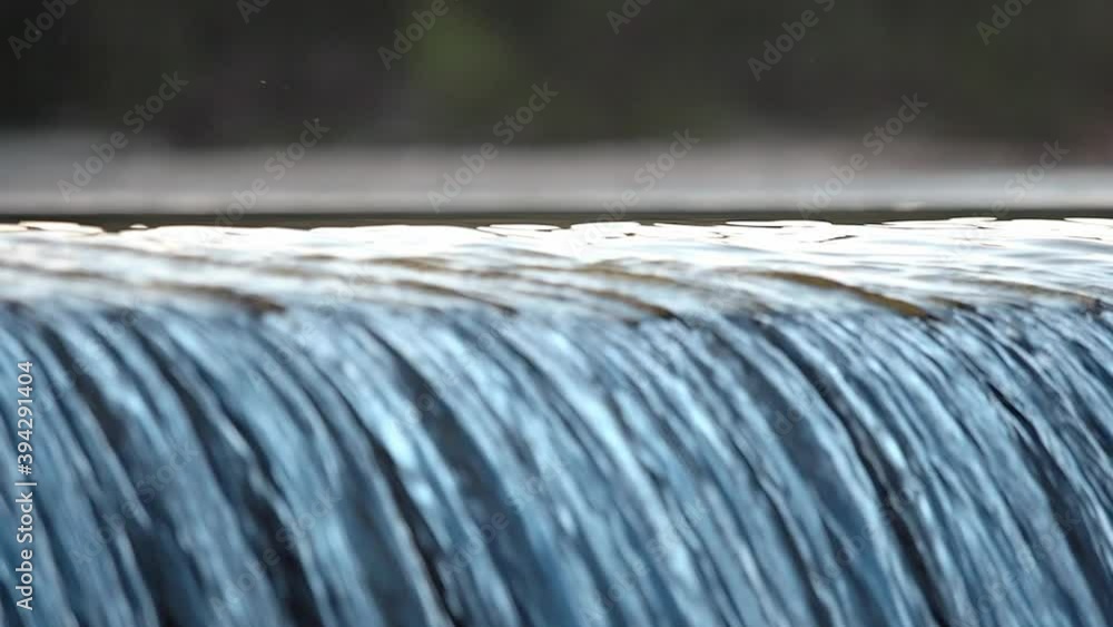 Close-up shot of a waterfall with a forest in the background Close-up shot of a waterfall with a forest in the background