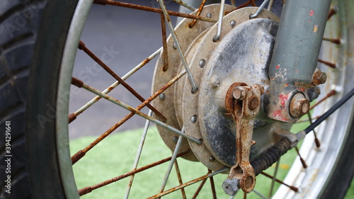 Front wheel hub and motorcycle spokes. Old vintage motorcycle with peeling paint and rust in vintage style. Close focus and select an object