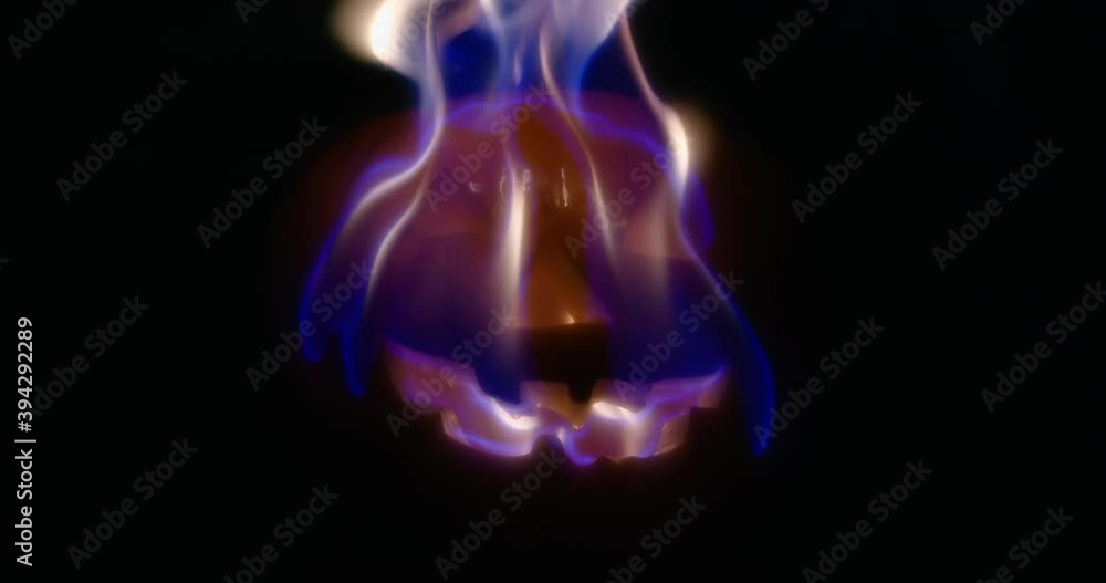 Slow motion medium shot of a jack-o-lantern as its face burns. Slow motion medium shot of a jack-o-lantern as its face burns.