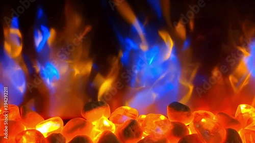 Close up of electric fireplace. Rocks at the bottom at the fireplace and red and blue flames simulation constantly moving. photo