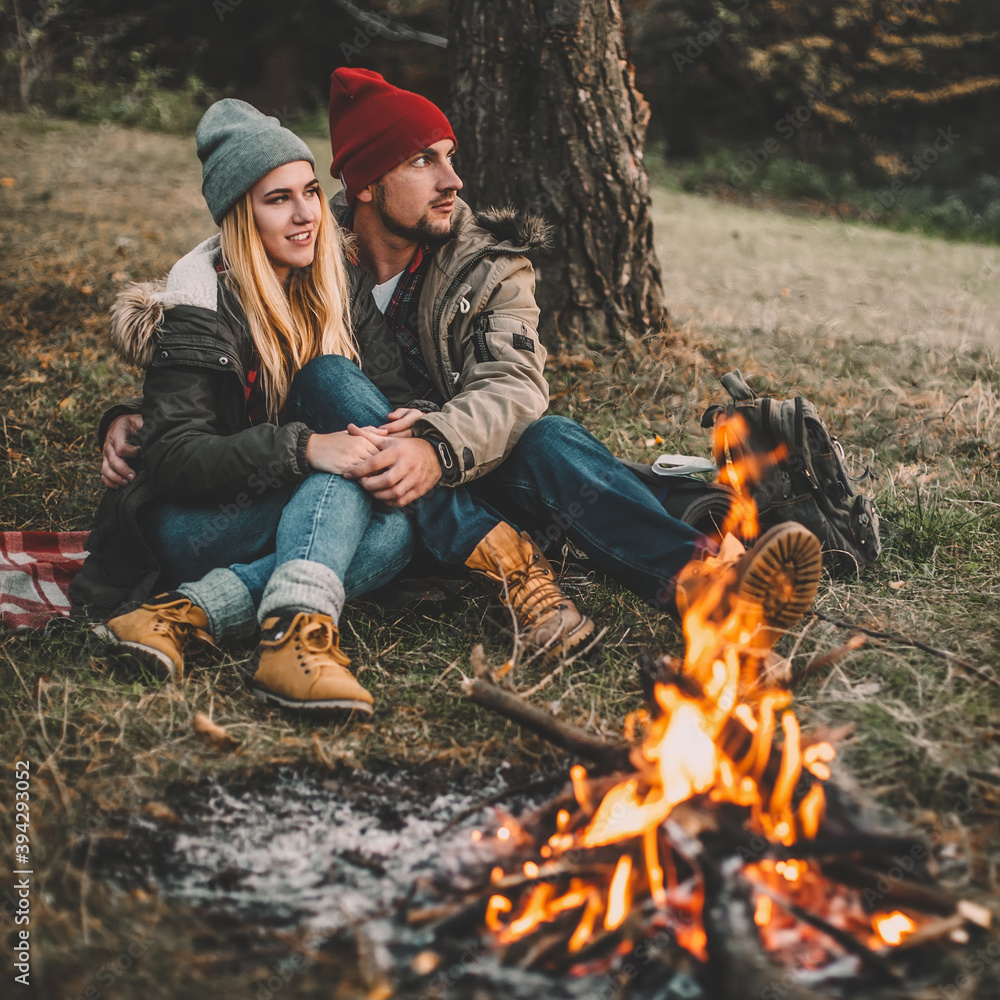 Traveler couple camping in the forest and relaxing near campfire after a hard day. Concept of trekking, adventure and seasonal vacation. Traveler couple camping in the forest and relaxing near campfire after a hard day. Concept of trekking, adventure and seasonal vacation.