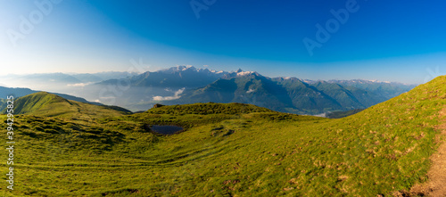 Fototapeta Naklejka Na Ścianę i Meble -  Scenic summer view on snowy grossglockner peak and nordlicher bockkarkees in sunny day with green meadows, pine tree forests, hills, blue sky. Europe alps in austria