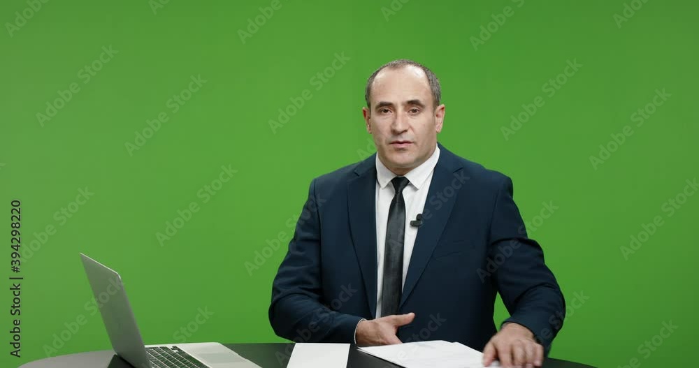 Male television anchor is talking about current news. Serious professional tv channel broadcast news reporter looking at camera. Green background chroma key template 4k footage Male television anchor is talking about current news. Serious professional tv channel broadcast news reporter looking at camera. Green background chroma key template 4k footage