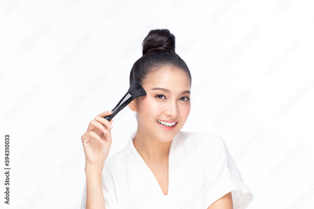 Closeup portrait of beautiful happy young girl holding brush near face isolated on white background. Beauty and cosmetics concept. Closeup portrait of beautiful happy young girl holding brush near face isolated on white background. Beauty and cosmetics concept.