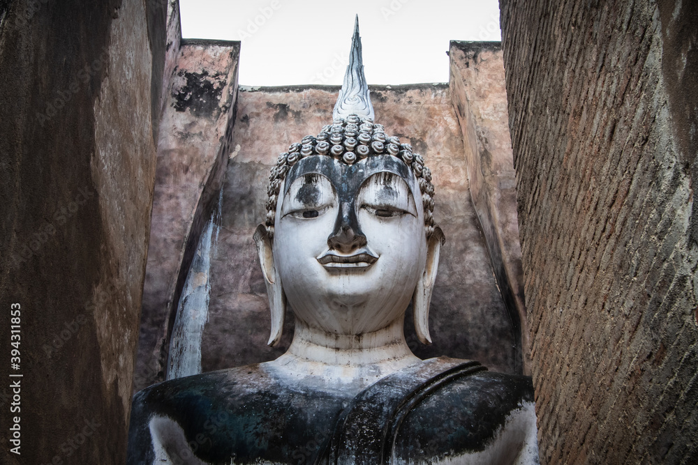 Closeup sitting Buddha statue with old bricks background at Wat Sri Chum, Sukhothai Historical Park, Unesco world heritage, Sukhothai, Thailand