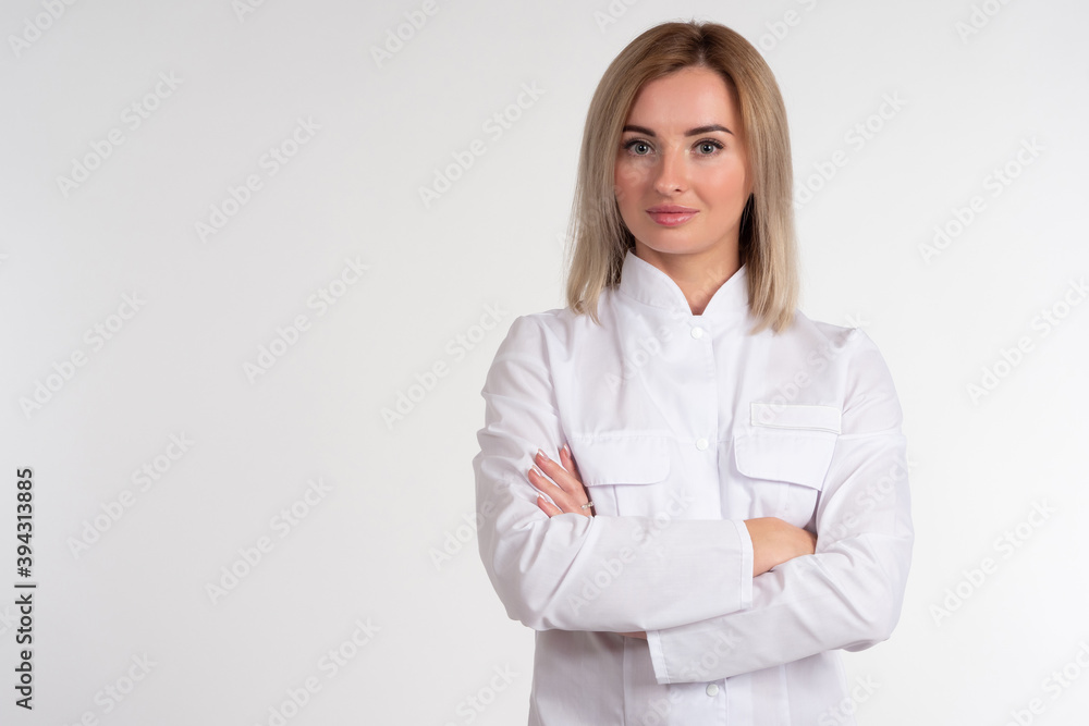 Portrait of a blonde in a white coat. Girl in a white uniform. Woman on a light background looks into the camera. Concept - a woman works in the field of cosmetology or medicine. Businesswoman Portrait of a blonde in a white coat. Girl in a white uniform. Woman on a light background looks into the camera. Concept - a woman works in the field of cosmetology or medicine. Businesswoman