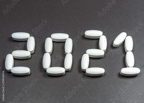 A lettering 2021 created by pills on the dark background. photo