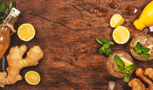 Ginger Ale Cocktail with Beer, Lime, Lemon and Mint in glaass on wooden table, top view