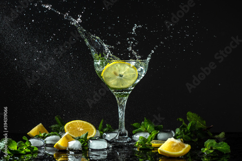 Lemonade with fresh lemon. fresh drink with liquid splash, freeze motion in jar glass on dark background