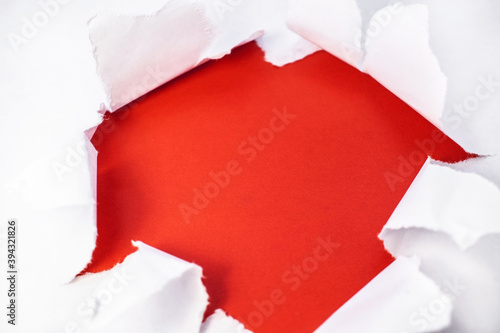 In the center is a torn white sheet with ragged edges inside which is a red background with space for text.