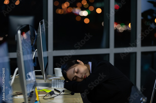 Asian lady call center worker employee sleeping on dest at night photo