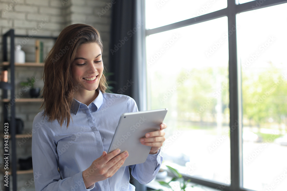 Attractive smiling woman working on a tablet in a home office. Attractive smiling woman working on a tablet in a home office.