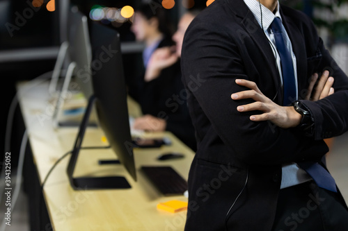 Businessman working overtime late at night in call center office with colleague team.