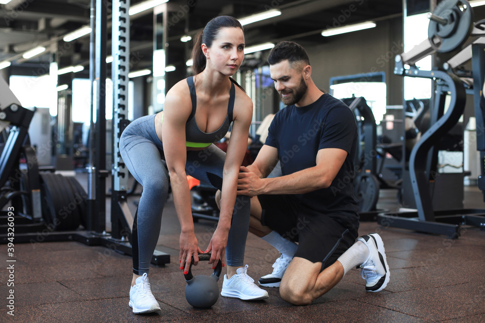 Obraz premium Fitness instructor exercising with his client at the gym.