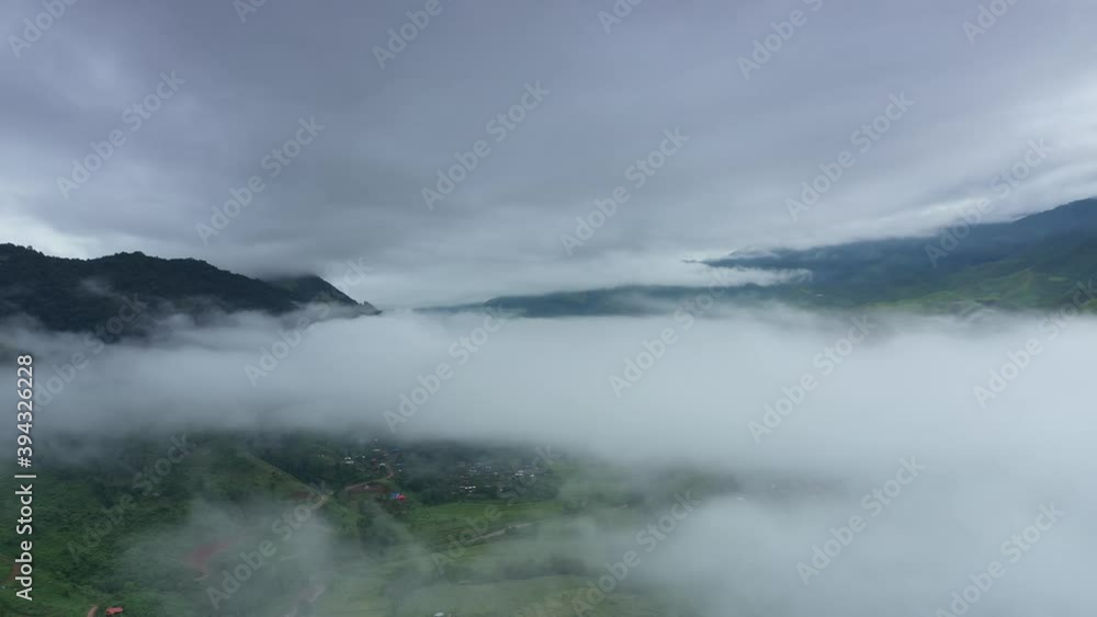 Aerial view over valley surrounded by mountains and covered with dense ground fog and mist High peaks wonderful morning sunrise natural Landscape. Sapan village, nan province, Thailand. Aerial view over valley surrounded by mountains and covered with dense ground fog and mist High peaks wonderful morning sunrise natural Landscape. Sapan village, nan province, Thailand.