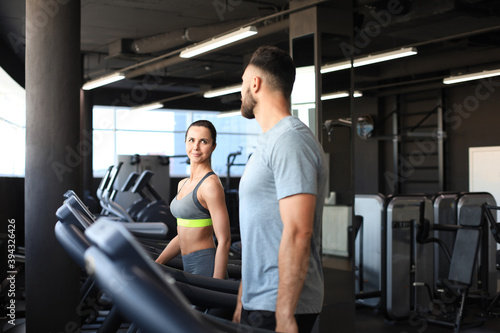 Healthy sport couple running on a treadmill in a sport gym.