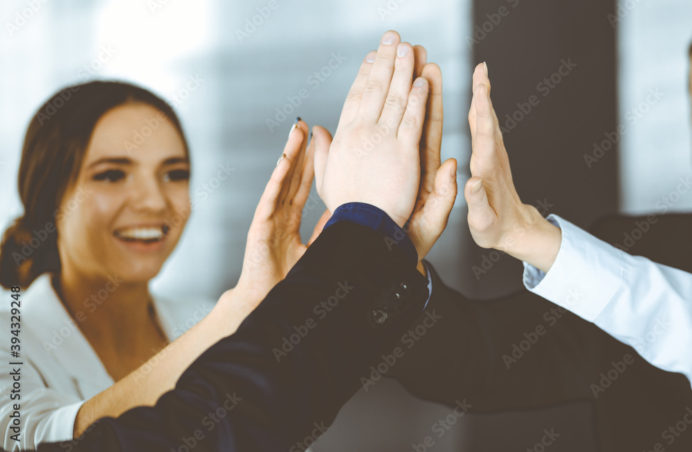 Young businesspeople are celebrating success of their project, standing